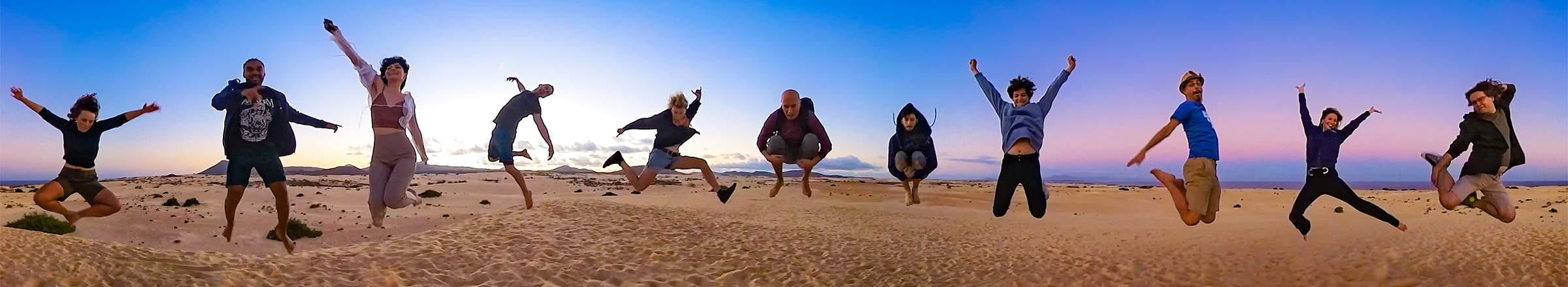 SmarterQueue Team jumping in sand dunes